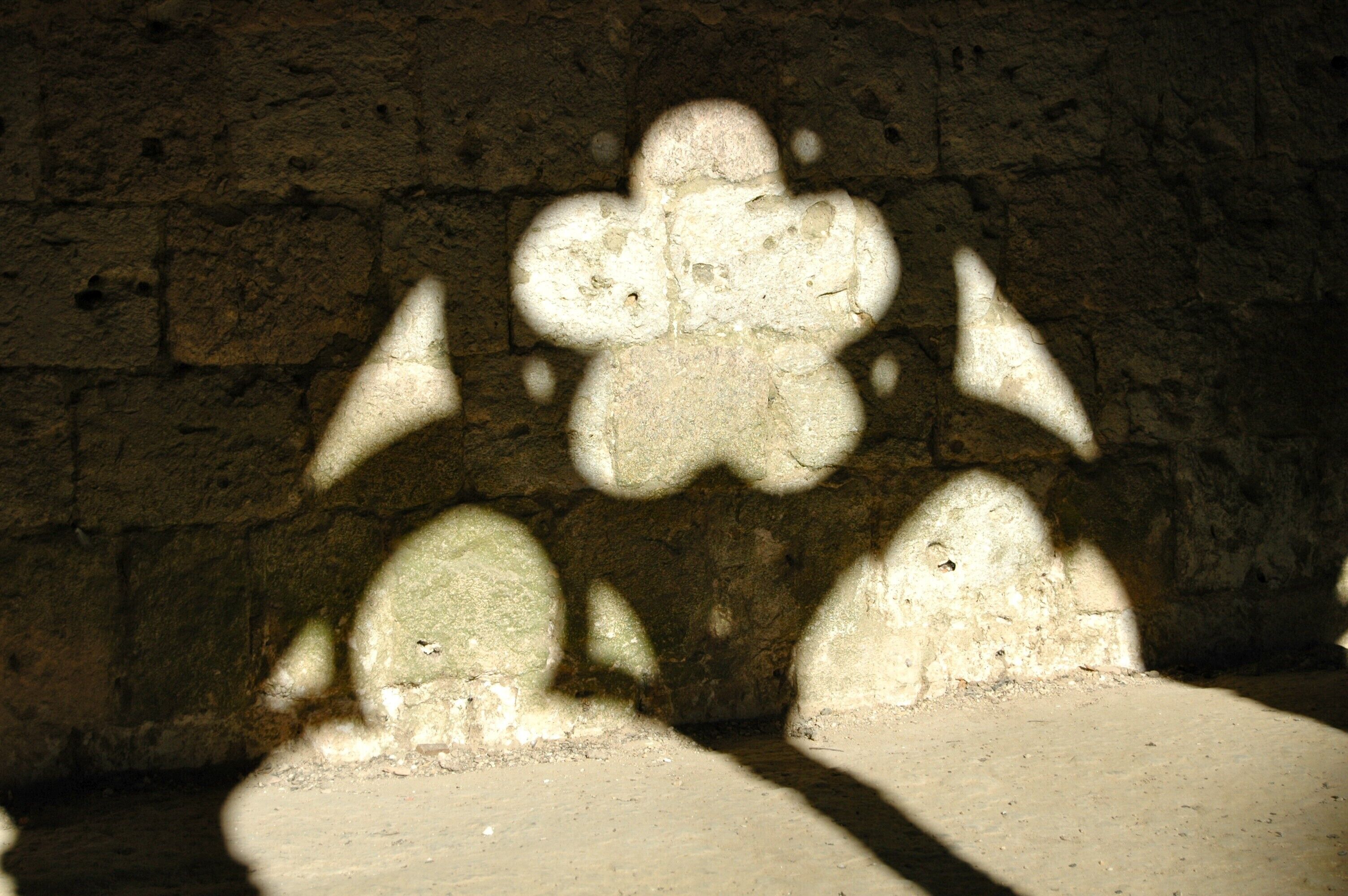 A stone wall with shadow patterns.
