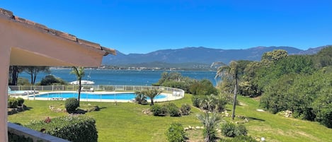 A pool with a view of the sea and mountains.