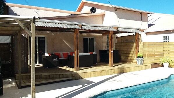 A covered outdoor patio with a pool, wooden deck, and a sofa set. - Mon Zarlor 3* luxury villa with private heated pool (SAINT PIERRE)