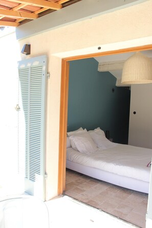 Une chambre à coucher avec un lit, une porte et un ventilateur de plafond.