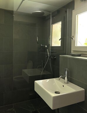 Une salle de bain moderne équipée d’une douche, de toilettes et d’un lavabo.