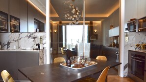 Une cuisine moderne dotée de plans de travail en marbre, d’un îlot central et d’un lustre.