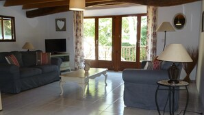 A living room with two sofas, a coffee table, a TV, and a lamp. - Character cottage with all the charm of the countryside (Anglars-Saint-Félix)