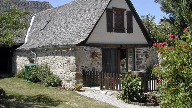 A stone cottage with a sloped roof, wooden shutters, and a small porch with a wooden fence. - Character cottage with all the charm of the countryside (Anglars-Saint-Félix)