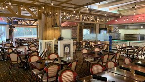 A restaurant with wooden beams, wicker chairs, and a kitchen area. - Palm Beach Shores Ocean Front Resort, Singer Island One Bedroom ~ Valet Parking (Palm Beach Shores)