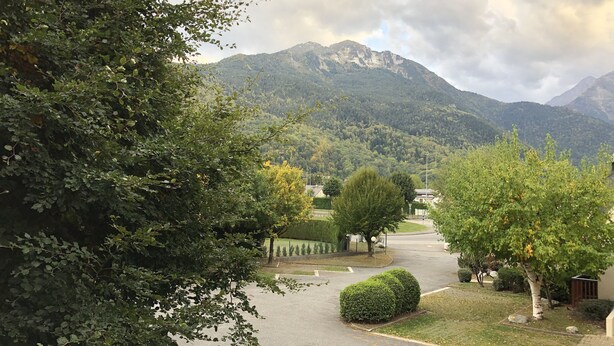 Une rue résidentielle offrant une vue sur les montagnes en arrière-plan.