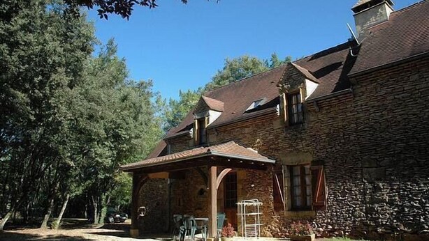 A stone building with a covered patio and outdoor seating area. - COTTAGE *** with pool near Sarlat, Dordogne Périgord Noir (Prats-De-Carlux)