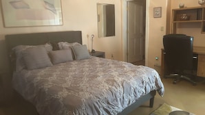 Ein Schlafzimmer mit einem großen Bett, einem Schreibtisch und einem Stuhl.