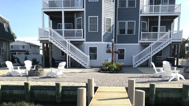A multi-story building with balconies and a wooden deck area. - Bayfront with dock and fire pit, @ Harris Harbor, Beach  Haven Park, LBI (Long Beach Township)