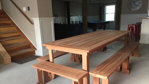 A wooden picnic table with benches in a living room with a staircase and a clock on the wall. - Bayfront with dock and fire pit, @ Harris Harbor, Beach  Haven Park, LBI (Long Beach Township)