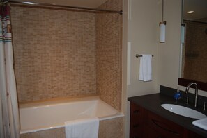 Ein Badezimmer mit einer Badewanne, einem Waschbecken und einem Spiegel.