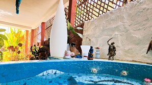 A pool with mosaic tiles, surrounded by decorative items and plants. - Studio le petit Marrakech, ILE DE NGOR Private boat swimming pool and Jaccuzi Air conditioning (Dakar)