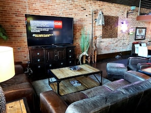 Relax in this stylish living room with a flat-screen TV, leather sofas, and a coffee table.