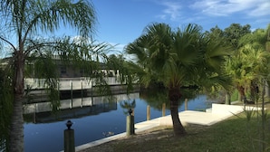 A calm water body with palm trees and a bridge. - Villa Alegria, Your Home Away From Home! (Cape Coral)