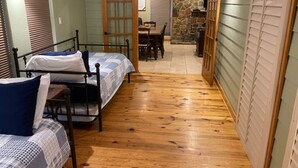 Een kamer met twee bedden, een eettafel en een stenen open haard.