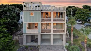 Una casa a più piani con un balcone al secondo piano, un garage e un vialetto.