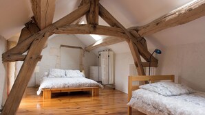 A bedroom with a wooden ceiling, a bed, a chair, and a bedside table. - Charming Cottage Set In The Loire Valley Just Minutes From Sancerre (Feux)