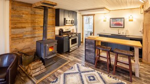 Una cocina moderna con estufa de leña, electrodomésticos de acero inoxidable y una zona de bar.