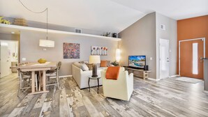 A modern living room with a dining table, sofa, and TV. - Fabulous Location @ Rancho Relaxo  (La Quinta)