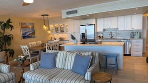 Una cocina moderna con armarios blancos, un refrigerador de acero inoxidable y una isla central.