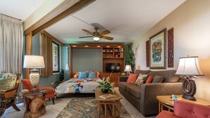 A spacious living room with a large bed, a sofa, a coffee table, and a television. - OCEAN VIEW - SLEEP 6! -Single Level - Family Room -No Stairs-Steps to Beach! (Kihei)