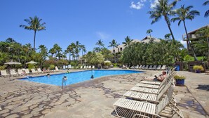 A pool area with lounge chairs and palm trees. - OCEAN VIEW - SLEEP 6! -Single Level - Family Room -No Stairs-Steps to Beach! (Kihei)