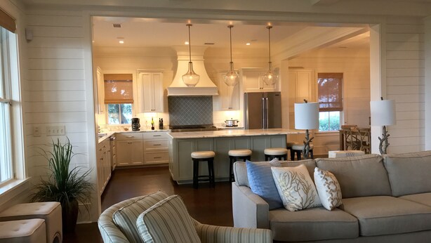 A modern kitchen with a central island, bar stools, and pendant lighting. - Beautiful Oceanfront 5 Bedroom Home With Pool  (Isle of Palms)