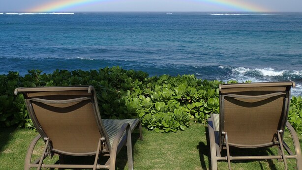 Two lounge chairs facing a view of the ocean with a rainbow. - North Shore Ocean-View Garden Cottage near Paia – Maui by the Sea (Paia)