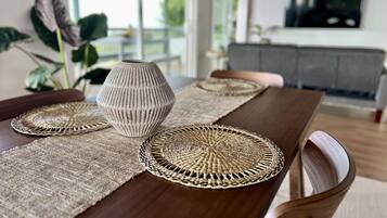 Une table à manger avec des sets de table en fibres tressées et un vase.