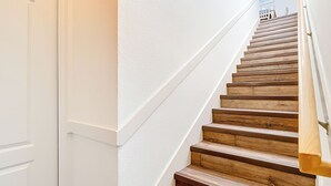 Eine Treppe mit Holzbodenstufen und weißen Wänden.
