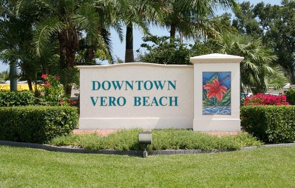 A sign for Downtown Vero Beach with a decorative flower painting. - 5 Min Walk - Golf Cart Included - Central Beach - House w Large Backyard & Pool (Vero Beach)