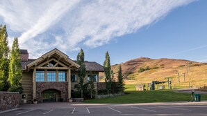 A lodge with a stone facade, large windows, and a parking lot. - Snow Creek Condo with 2 Bedrooms, 2 Bathrooms and expanded ground level patio !! (Sun Valley)