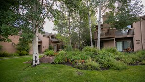 A residential building with a well-maintained garden, including a variety of plants and flowers. - Snow Creek Condo with 2 Bedrooms, 2 Bathrooms and expanded ground level patio !! (Sun Valley)