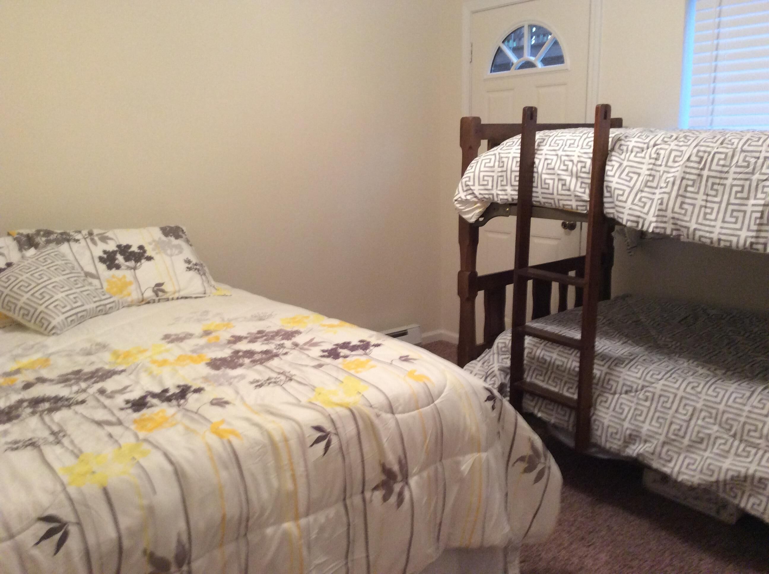 Ein Schlafzimmer mit zwei Etagenbetten, eines mit Blumenmuster und das andere mit einem geometrischen Muster.