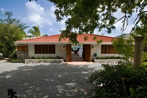 A building with a red-tiled roof, stone walls, and wooden shutters.