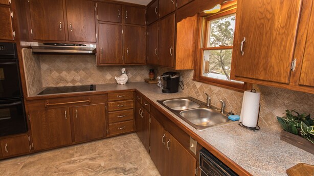 Una cocina con armarios de madera, electrodomésticos de acero inoxidable y un ventanal.