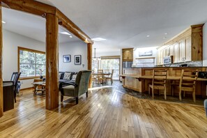 A spacious kitchen with wooden cabinets and a dining area with a table and chairs. - Snowy Creek 30 - Ski in Ski out, Private Hot Tub, Short Walk to Whistler Village (Whistler)