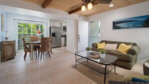 Un vaste espace de vie comprenant une table à manger, des chaises, un canapé et un ventilateur de plafond.