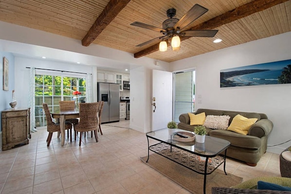 A spacious living area with a dining table, chairs, a sofa, and a ceiling fan. - Selva 150 · Strands Beach Beauty, Gorgeous Luxury Condo (Dana Point)