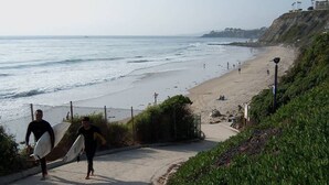 Une promenade en bord de mer, avec une plage et l’océan en arrière-plan.