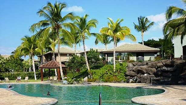 A swimming pool with a circular design, surrounded by palm trees and a gazebo. - Welcome to the Beauty that is Mauna Lani Fairways Unit 1301! (Kamuela)