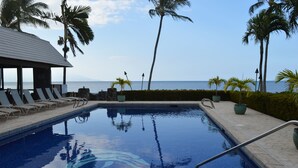 A swimming pool with lounge chairs, a covered seating area, and a view of the ocean. - Peaceful Ocean View. Ground Floor. Classy, clean and quiet. (Kaunakakai)