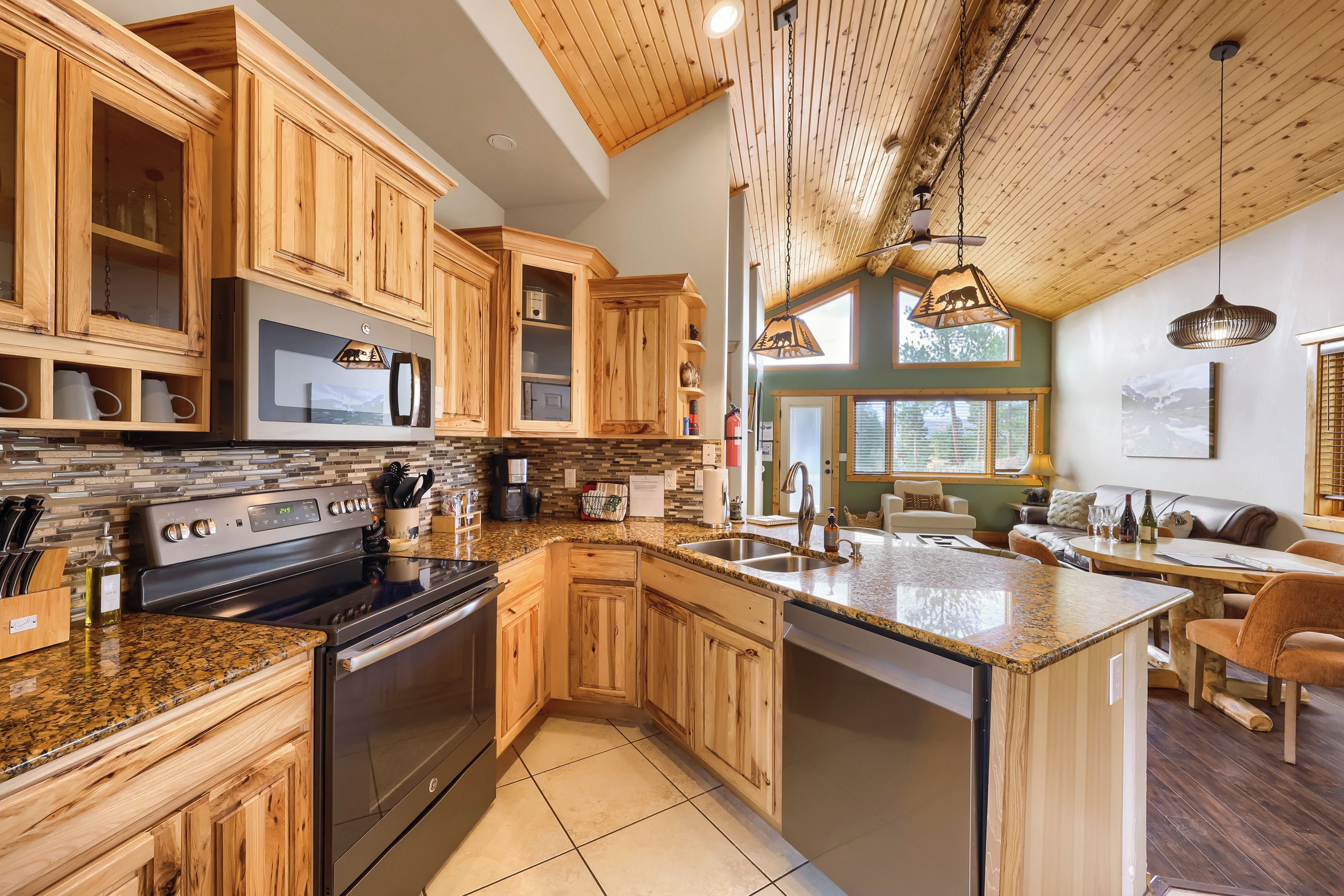 A modern kitchen with wooden cabinets, a stainless steel stove, and a granite countertop.