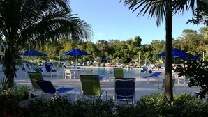 Un área de piscina con sillones de descanso y sombrillas.
