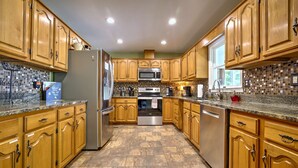 A spacious kitchen with wooden cabinets, stainless steel appliances, and a tiled backsplash. - Peaceful Lakefront, Spectacular View, Spacious 2 Level, 30 Min from Auburn (Alexander City)