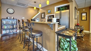 A kitchen with a bar area, a bookshelf, and a clock on the wall. - Peaceful Lakefront, Spectacular View, Spacious 2 Level, 30 Min from Auburn (Alexander City)