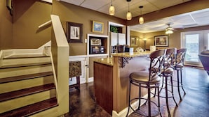 A kitchen with a central island, bar stools, and a staircase. - Peaceful Lakefront, Spectacular View, Spacious 2 Level, 30 Min from Auburn (Alexander City)