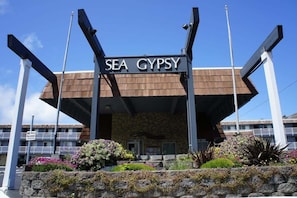 Welcome to Sea Gypsy, a charming building with a stone facade and beautifully landscaped gardens.