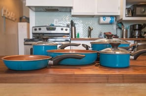 Kitchen area with a stainless steel stove, oven, and white cabinets.