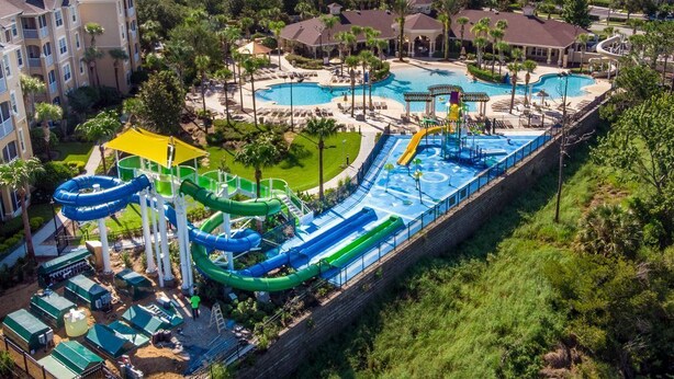A resort with multiple swimming pools, a water park, and a large building complex.
